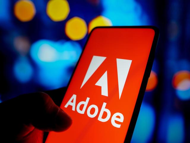 In this photo illustration, the Adobe Inc. logo seen displayed on a smartphone screen.
