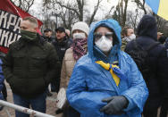 Protesters in face masks take part in a rally in front of the parliament building in Kyiv, Ukraine, Tuesday, March 17, 2020. Protesters demanded lawmakers to stop working amid nation-wide quarantine in order to prevent hastily adopting unpopular laws. In an additional set of measures preventing the spread of the new coronarivus, Ukrainian authorities ruled to close public places except food markets, pharmacies and gas stations starting from Tuesday in Kyiv and other regions, and restrict the use of public transport from Kyiv to other Ukrainian cities. For most people, the new coronavirus causes only mild or moderate symptoms. For some it can cause more severe illness, especially in older adults and people with existing health problems. (AP Photo/Efrem Lukatsky)