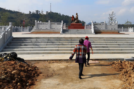 A woman takes a selfie with a statue of late Chinese chairman Mao Zedong in Shazhou village, Rucheng county, Hunan province, China December 3, 2018. Picture taken December 3, 2018. REUTERS/Shu Zhang