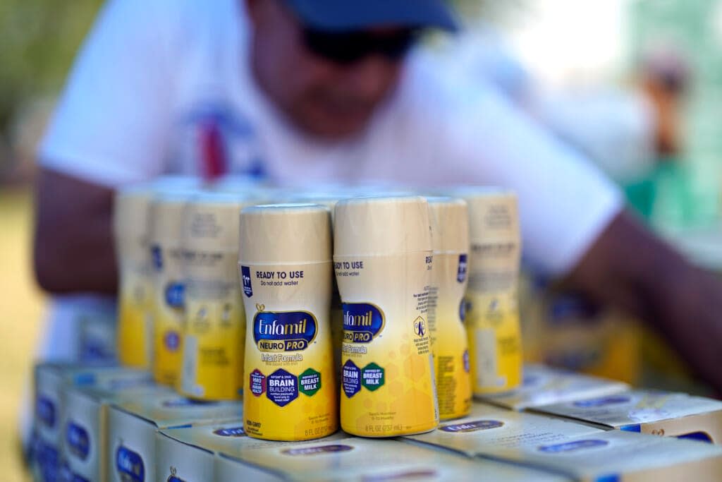Infant formula is stacked on a table during a baby formula drive to help with the shortage Saturday, May 14, 2022, in Houston. (AP Photo/David J. Phillip)