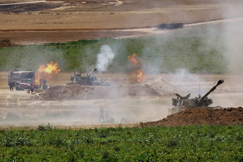 An Israeli military artillery unit fires a shell, as seen from the Israeli side of the border with the Gaza Strip