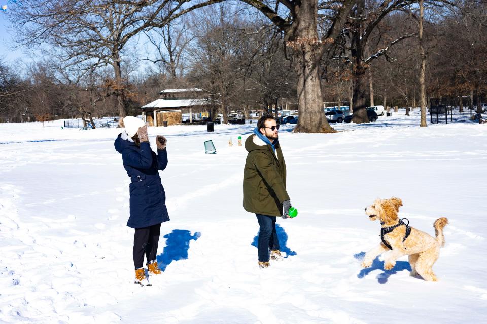 Genevieve Kuhar, left, and Brody Kuhar play in the snow with their dog Maggie at Overton Park in Memphis, Tennessee, on Wednesday.