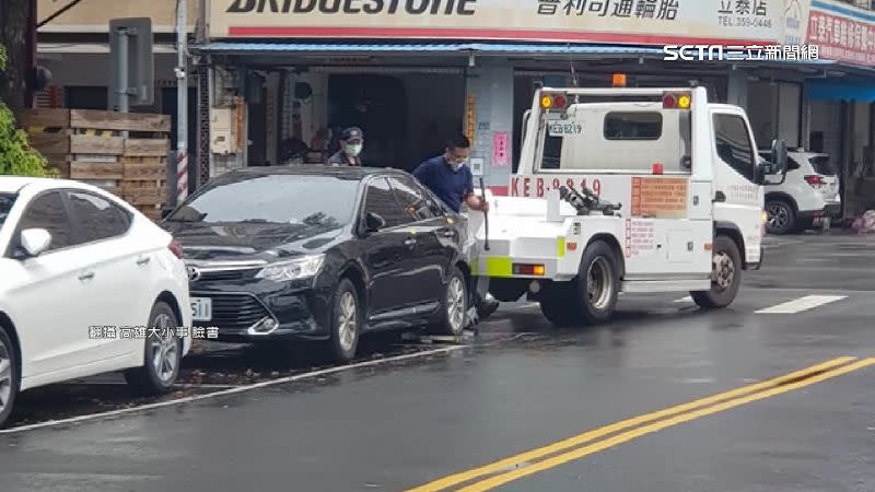 黑色轎車因後車輪超出停車格遭拖吊。（圖／翻攝自高雄大小事臉書）