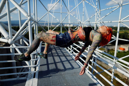 Kaitlin, 28, from the United States is suspended from hooks pierced through her skin by the professional body artist Dino Helvida in Zagreb, Croatia June 7, 2016. REUTERS/Antonio Bronic