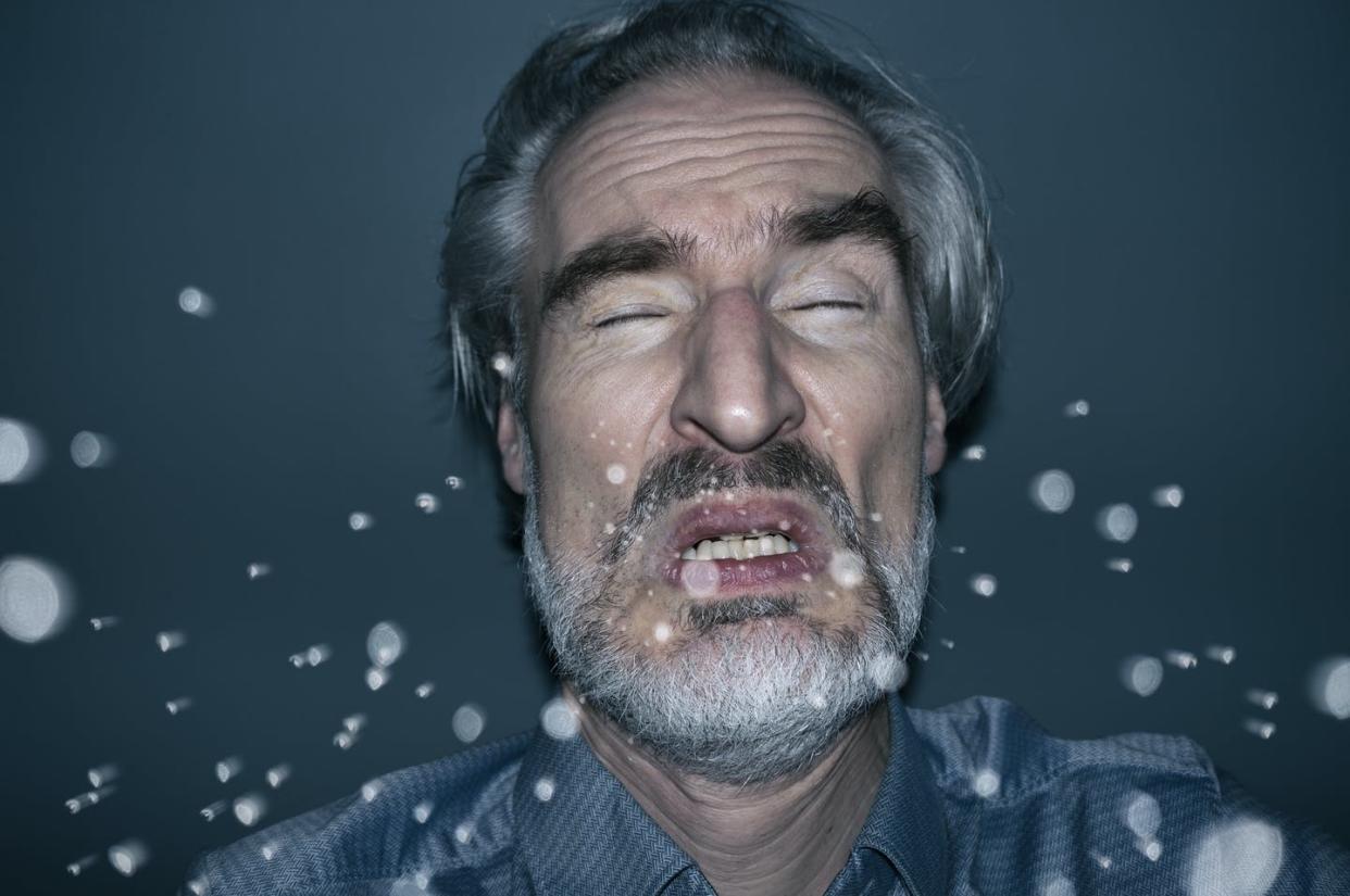 <span class="caption">When a person sneezes, tiny droplets, or aerosols, can linger in the air.</span> <span class="attribution"><a class="link " href="https://www.gettyimages.com/detail/photo/sneezing-man-royalty-free-image/1209729560" rel="nofollow noopener" target="_blank" data-ylk="slk:Jorg Greuel via Getty Images;elm:context_link;itc:0;sec:content-canvas">Jorg Greuel via Getty Images</a></span>