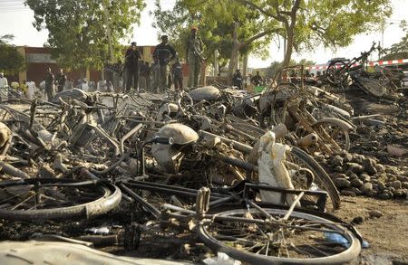 Police officers stand near wreckage at a scene of multiple bombings at Kano Central Mosque November 28, 2014. REUTERS/Stringer