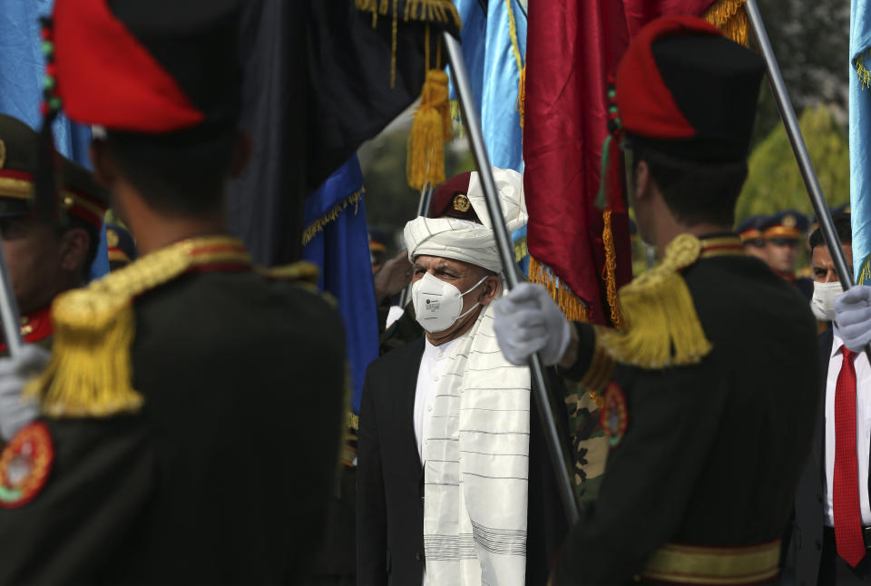 Afghan President Ashraf Ghani, center, inspects the honor guard during the Independence Day celebrations at the Defense Ministry in Kabul, Afghanistan, Tuesday, Aug. 18, 2020. (AP Photo/Rahmat Gul)