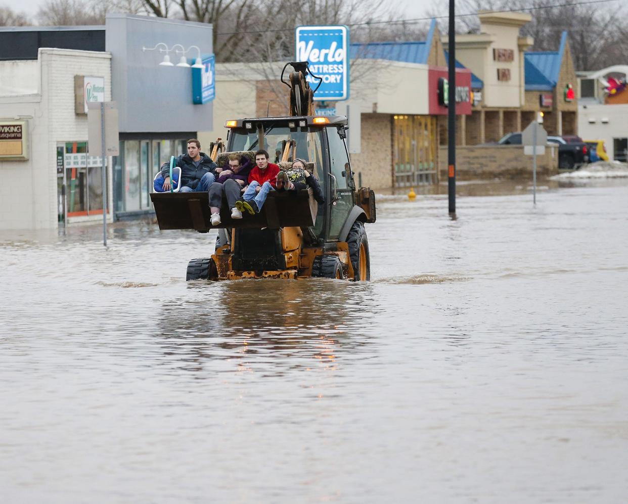 Four people are evacuated from a flooded area Thursday, March 14, 2019 on Johnson Street in Fond du Lac, Wis. Thursday, March 14, 2019. Ice jams on the east branch of the Fond du Lac River and heavy rain caused widespread flooding problems in the city. Doug Raflik/USA TODAY NETWORK-Wisconsin