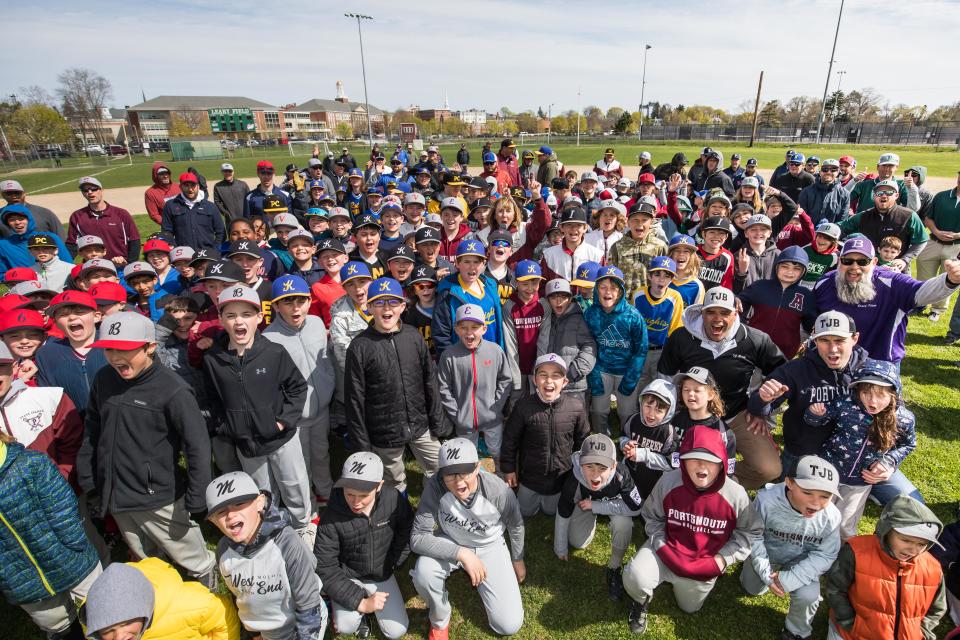 Players gather around Portsmouth Little League president Kathie Lynch as she announces, "Play Ball" on opening day 2022. The league's all-stars have now begun district tournament play.