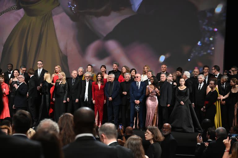 El director artístico de Cannes, Thierry Frémaux (a la izquierda) habla en el acto de celebración de los 75 años del Festival de Cannes, con una multitud de figuras en el escenario  