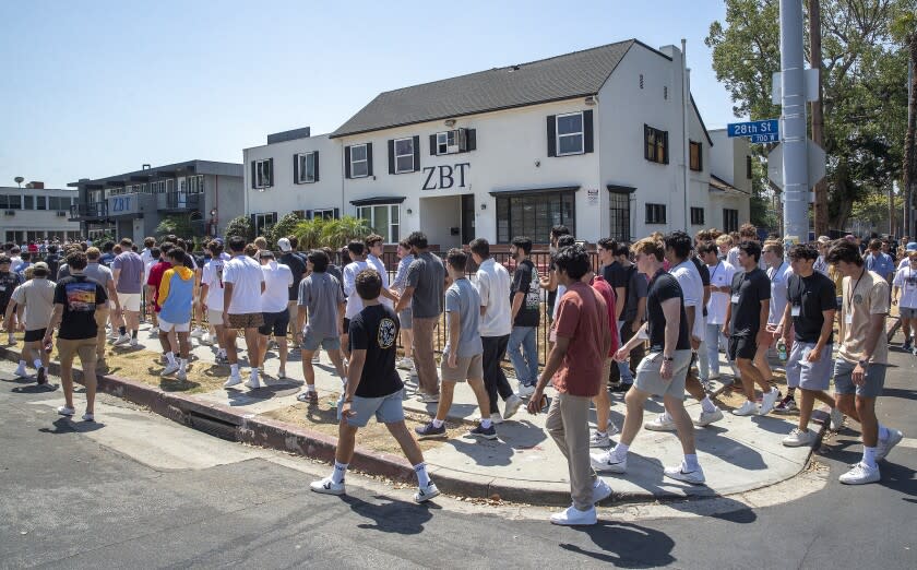 LOS ANGELES, CA -AUGUST 19, 2022:USC students walk by Zeta Beta Tau fraternity house while making their way along USC fraternity row, 28th St. in Los Angeles, during the kick off of rush week. Several fraternities including Zeta Beta TAu formally severed ties with USC earlier this month. Now those frats have come together to form the University Park Interfraternity Council. (Mel Melcon / Los Angeles Times)