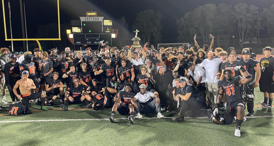 Ventura College head coach Steve Mooshagian holds the Citrus Cup aloft after the Pirates' 49-0 win over rival Moorpark College in the 54th Citrus Cup game Saturday night at VC Sportsplex.