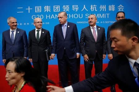 A security agent reacts as a woman tries to have a pictures taken in front of Turkey's President Tayyip Erdogan (C) and his delegation after the closing of G20 Summit in Hangzhou, Zhejiang Province, China, September 5, 2016. REUTERS/Damir Sagolj