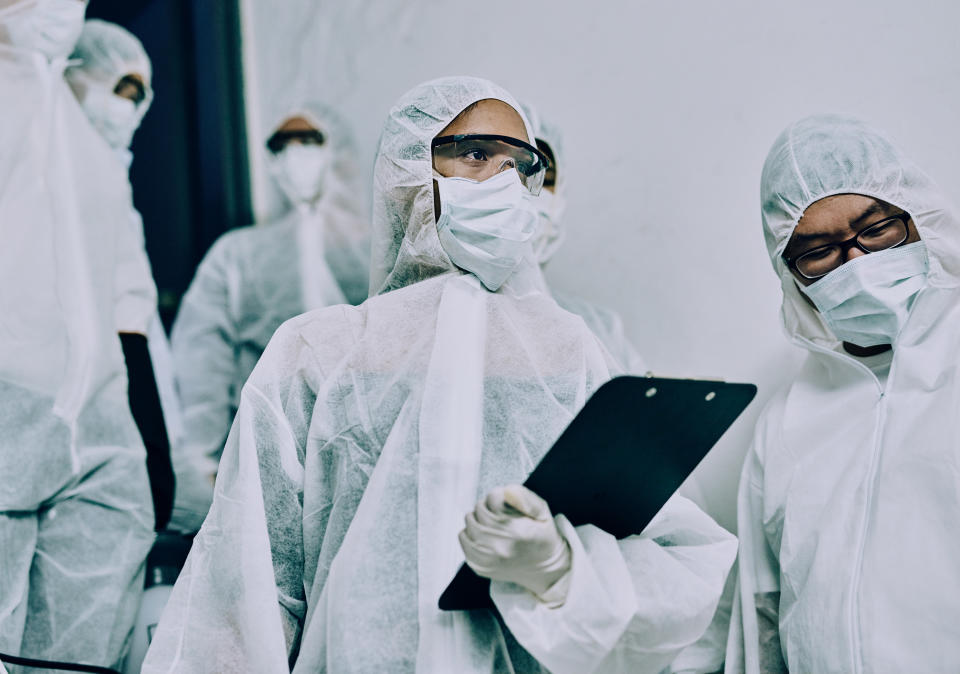 Shot of a group of healthcare workers wearing hazmat suits working together to control an outbreak