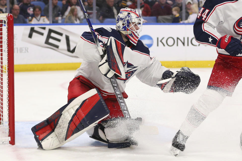 THIS CORRECTS THAT KIVLENIEKS DIED OF CHEST TRAUMA FROM AN ERRANT FIREWORKS MORTAR BLAST AND NOT A SUBSEQUENT FALL AS AUTHORITIES PREVIOUSLY REPORTED - FILE - Columbus Blue Jackets goalie Matiss Kivlenieks (80) makes a save during the first period of an NHL hockey game against the Buffalo Sabres in Buffalo, N.Y., in this Saturday, Feb. 1, 2020, file photo. The Columbus Blue Jackets and Latvian Hockey Federation said Monday, July 5, 2021, that 24-year-old goaltender Matiss Kivlenieks has died. A medical examiner in Michigan says an autopsy has determined that Columbus Blue Jackets goaltender Matiss Kivlenieks died of chest trauma from an errant fireworks mortar blast, and not a fall as authorities previously reported. Police in Novi, Michigan, said the mortar-style firework tilted slightly and started to fire toward people nearby Sunday night, July 4. (AP Photo/Jeffrey T. Barnes, File)