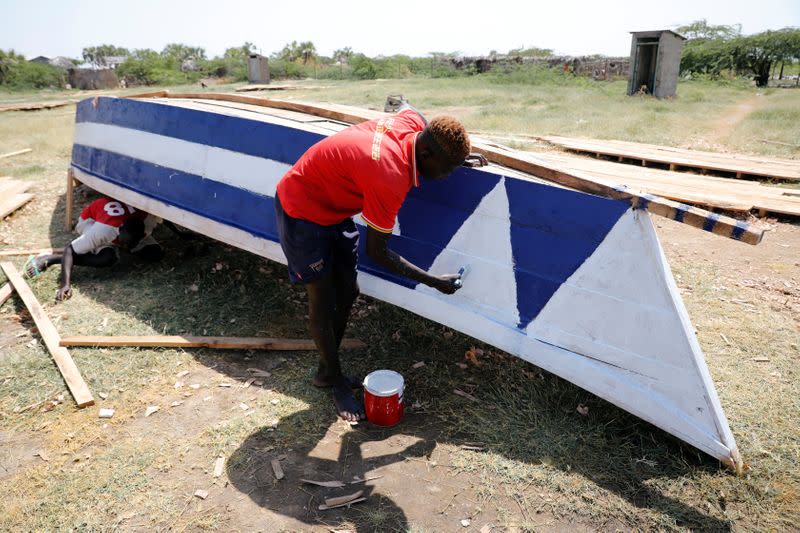A man paints a boat on a beach at Lake Turkana, near the town of Kalokol, Turkana county