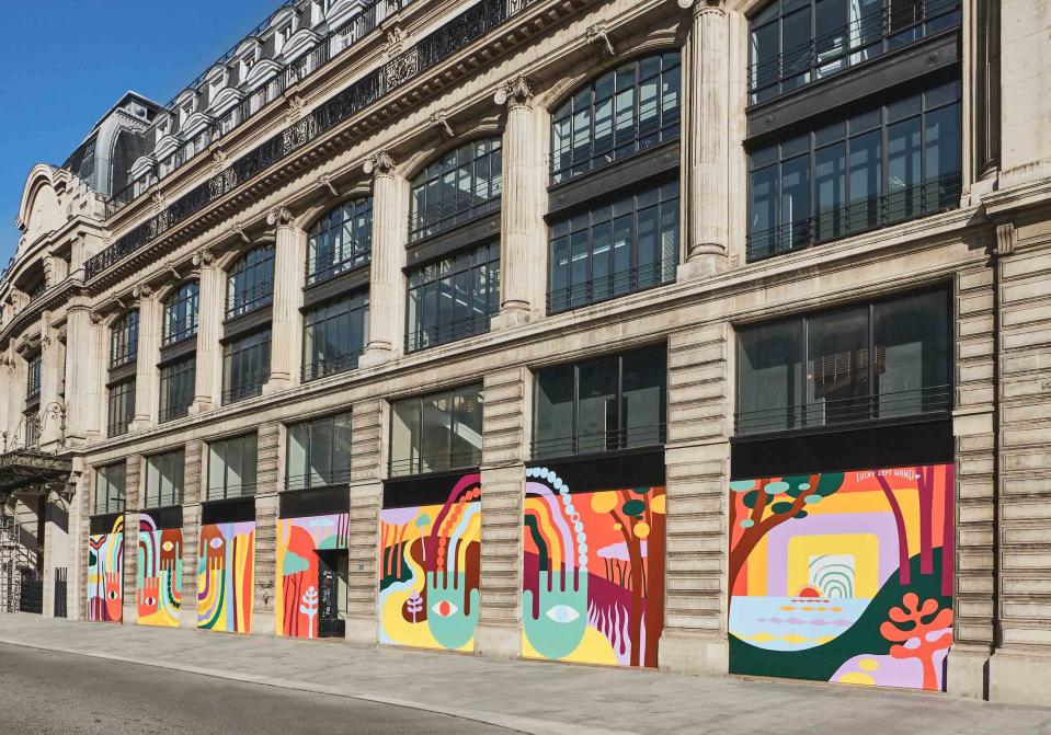 L’art s’invite dans les rues parisiennes. Après avoir conquis le public grâce à son Monogram ultra pop en 3D pour les fêtes de fin d’année, en décembre dernier, Louis Vuitton fait une nouvelle fois preuve de créativité. En effet, depuis le 17 mars dernier, la France s’est vue placée en confinement pour faire face à l’épidémie de Coronavirus qui sévit dans le monde, et la griffe entend diffuser un message d’optimisme et des ondes positives dans la capitale.Si d’ordinaire Louis Vuitton s’amuse à scénariser les vitrines de ses célèbres magasins parisiens, situés place Vendôme ou avenue des Champs-Élysées pour ne citer qu’eux, c’est bien dans le quartier du Pont Neuf, dans le premier arrondissement de Paris, que la marque a choisi d’exposer son art. En effet, elle a fait appel à l’artiste français Steven Burke, plus connu sous le pseudonyme Lucky Left Hand, pour habiller la façade de son siège social. Et le résultat est une nouvelle fois à la hauteur. Avec un style minimaliste et synthétisé inspiré des années 60, Lucky Left Hand, qui a eu carte blanche pour ce projet, a imaginé une longue fresque de 280m2, composée de quatorze peintures toutes plus colorées les unes que les autres. Sa volonté ? Inviter les passants à l’évasion à travers les paysages d’Hossegor, sa ville d’adoption. « Je souhaitais offrir, avec cette œuvre murale, une balade colorée aux Parisiens le long de ces 14 vitrines, comme un jour de vacances en été, tout en symbolisant au mieux cette période transitoire que nous traversons », a-t-il expliqué sur son travail.Réalisée intégralement avec de la peinture acrylique, la fresque met en avant des mains, signatures de Lucky Left Hand, séparées physiquement d’environ un mètre cinquante mais reliées entre elles par la pensée. Un clin d’œil évident à notre état d’esprit durant la période de confinement. « Avec cette fresque, réalisée avec des couleurs vives et saturées, j’espère avoir réussi à diffuser une énergie positive dont nous avons tous besoin en ce moment », conclut l’artiste.