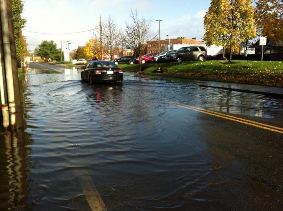 In this Oct. 30, 2012, photo, a car navigates Liberty Street in Brockton, in the aftermath of Hurricane Sandy.