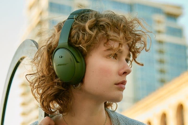 Woman wearing Bose QuietComfort Headphones in green.