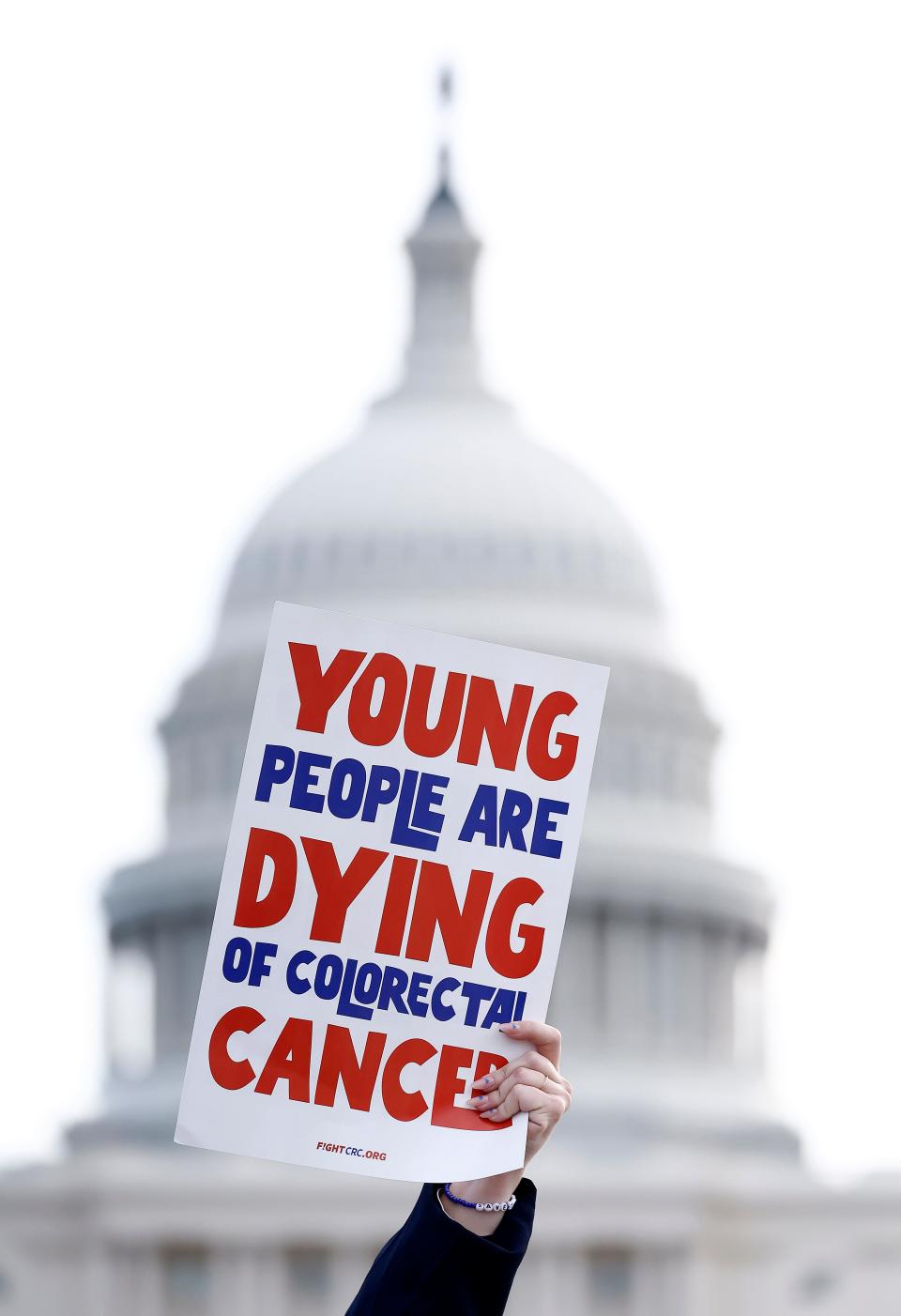 Advocates march to the U.S. Capitol to meet with members of Congress after gathering at the Fight Colorectal Cancer "United in Blue" flag installation on the National Mall spotlighting the rise in young adult Colorectal cancer cases on March 12, 2024 in Washington, DC.