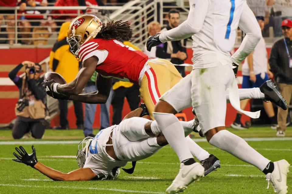 San Francisco 49ers wide receiver Brandon Aiyuk (11) catches a ball that bounced off the facemask of Detroit Lions cornerback Kindle Vildor (29) during the second half of the NFC Championship football game Sunday, Jan. 28, 2024, at Levi’s Stadium in Santa Clara.