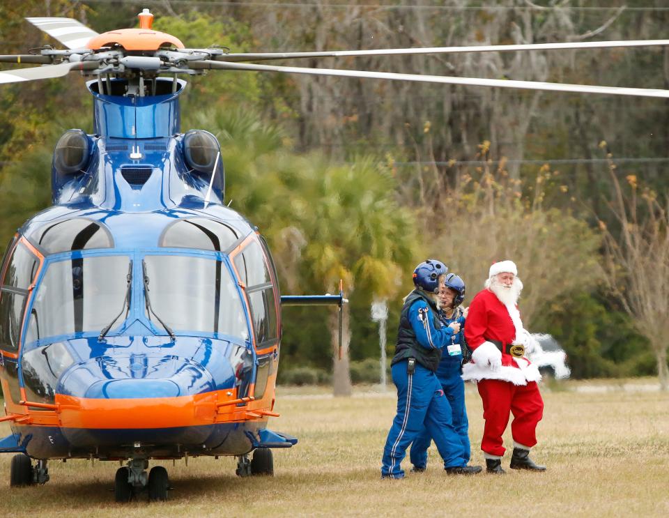 Santa arrives in the ShandsCair helicopter for the annual Operation Santa Delivery at the Santa Fe College field in 2017.