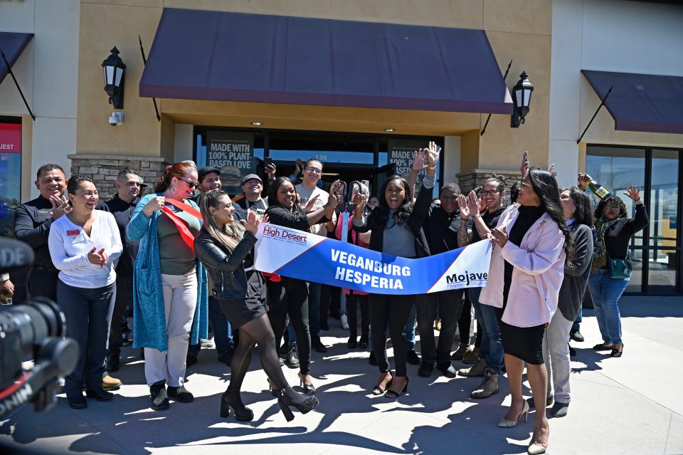 Owner Dee Johnson, center-right, cuts the ribbon with her sister and manager Lisa, center-left, to unveil Veganburg for the soft opening on Monday, April 15, 2024 in Hesperia.