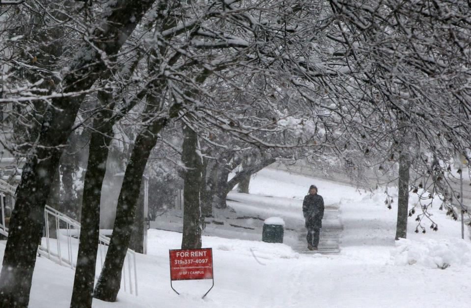 A person walks along Oakcrest Street in the snow Tuesday, Jan. 9, 2024 in Iowa City, Iowa.