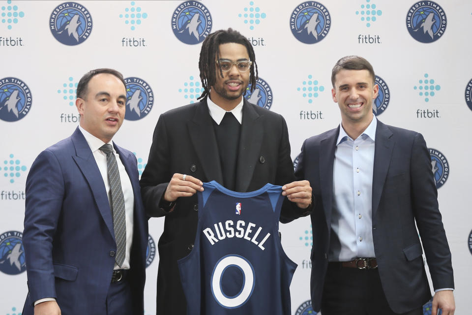 New Minnesota Timberwolves NBA basketball player D'Angelo Russell, center, holds his new jersey between President of Basketball Operations Gersson Rosas, left, and head coach Ryan Saunders during his introduction to the media, Friday, Feb. 7, 2020, in Minneapolis, following a trade that sent Timberwolves' Andrew Wiggins to the Golden State Warriors. (AP Photo/Jim Mone)