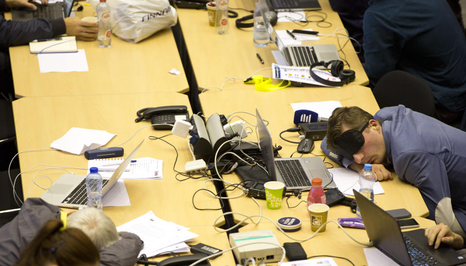 Journalists rest during a late night negotiating session at an EU summit in Brussels, Monday, July 1, 2019. European Union leaders participated in another marathon session of talks desperately seeking a breakthrough in a diplomatic fight over who should be picked for a half dozen of jobs at the top of EU institutions. (AP Photo/Virginia Mayo)
