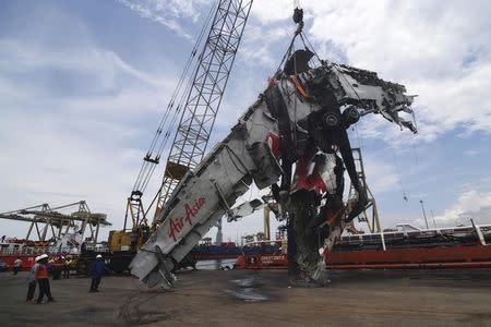 Workers unload the fuselage of AirAsia QZ8501, which crashed into the Java Sea on Dec. 28, from the ship Onyx Crest in Tanjung Priok port in Jakarta March 2, 2015. REUTERS/Antara Foto/Zabur Karuru/Files