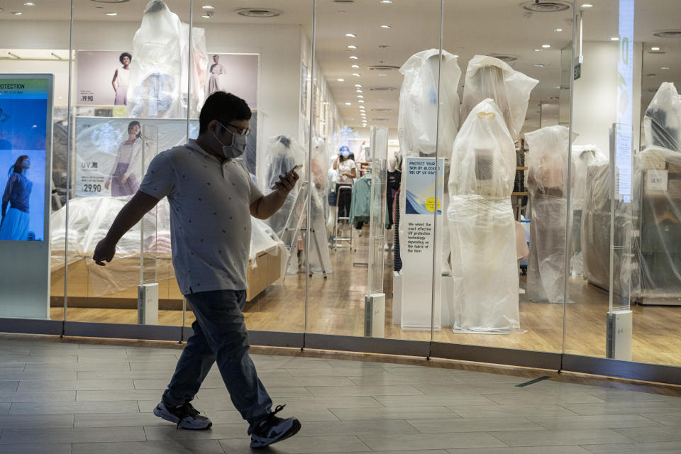 A man wearing a protective mask walks past a closed retail store in a shopping mall in Singapore. (PHOTO: Getty Images)