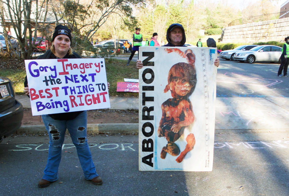 A pro-choice protester stands next to an anti-abortion protester at the entrance of APWHC Charlotte.&nbsp;