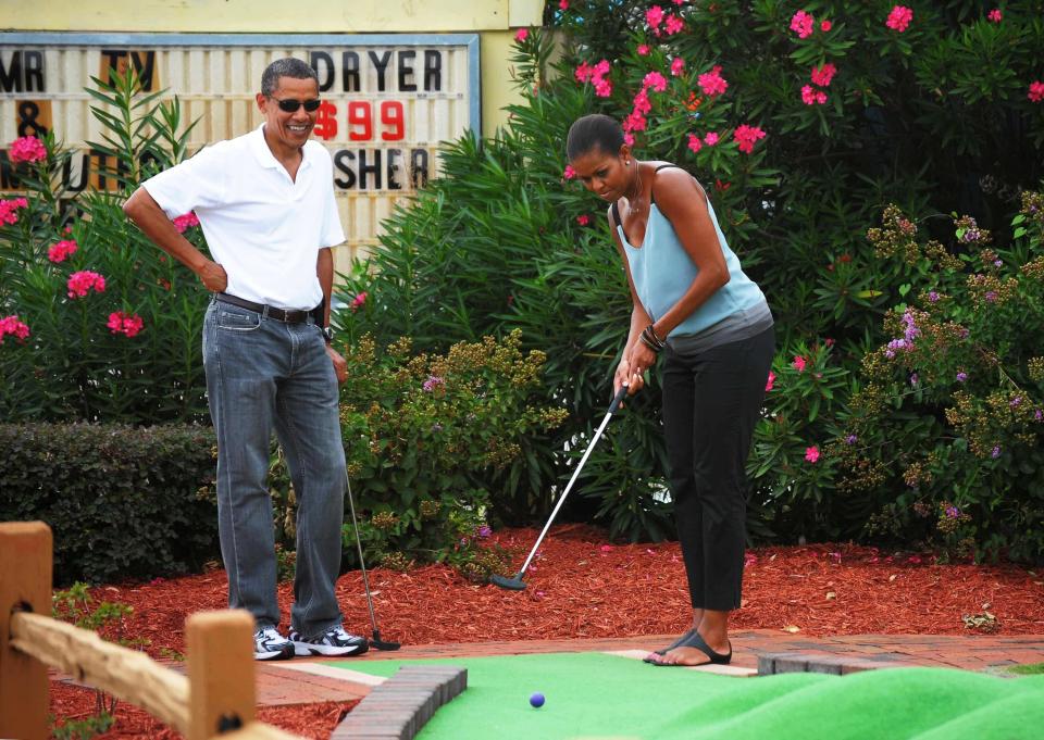 Barack Obama watches as Michelle Obama putts during a round of mini golf at Pirate's Island Golf on Aug. 14, 2010, in Panama City Beach, Florida.