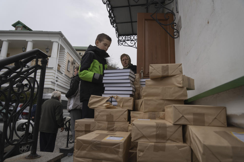 People take free spiritual books at a library of the Monastery of the Caves, also known as Kyiv-Pechersk Lavra, one of the holiest sites of Eastern Orthodox Christians, in Kyiv, Ukraine, Thursday, March 23, 2023. Tensions are on the rise at a prominent Orthodox monastery in Kyiv where the monks are facing eviction later this month. The Ukrainian government accuses the monks of links to Moscow, even though they claim to have severed ties with the Russian Orthodox Church following Russia's full-scale of invasion of Ukraine. (AP Photo/Efrem Lukatsky)