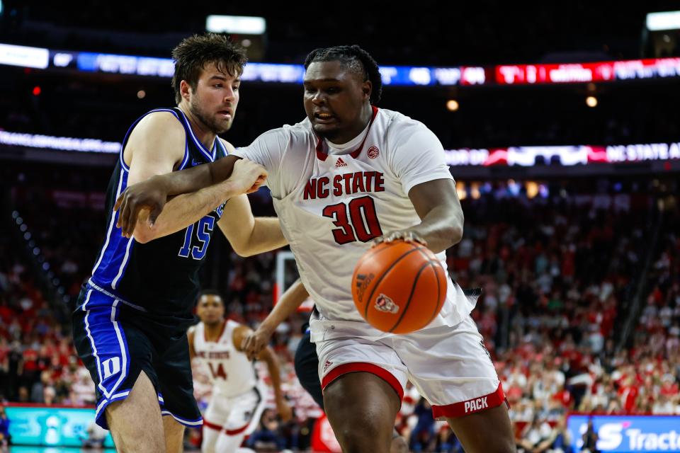 North Carolina State forward DJ Burns Jr. (30) dribbles the ball while being guarded by Duke center Ryan Young (15) during the first half at PNC Arena.