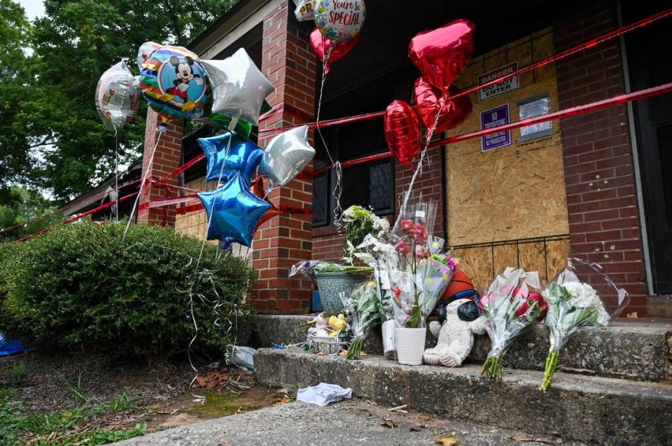 Balloons, flowers and stuffed animals are left as a memorial outside the Chapman Homes unit that caught fire Aug. 20, 2023 and took the lives of three youths.