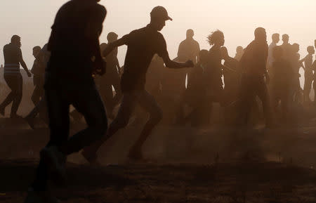 Palestinians run during a protest calling for lifting the Israeli blockade on Gaza and demanding the right to return to their homeland, at the Israel-Gaza border fence east of Gaza City September 28, 2018. REUTERS/Mohammed Salem