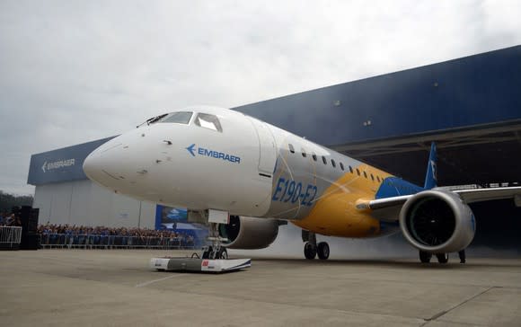 The first Embraer E190-E2 jet parked in front of a hangar