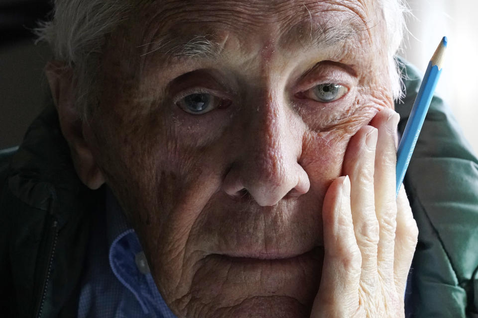 Artist Robert Seaman poses in his room at an assisted living facility Monday, May 10, 2021, in Westmoreland, N.H. Seaman, who moved into the facility weeks before the COVID-19 pandemic shutdown his outside world in 2020, recently completed his 365th daily sketch, or what he calls his "Covid Doodles", since being isolated due to the virus outbreak. (AP Photo/Charles Krupa)