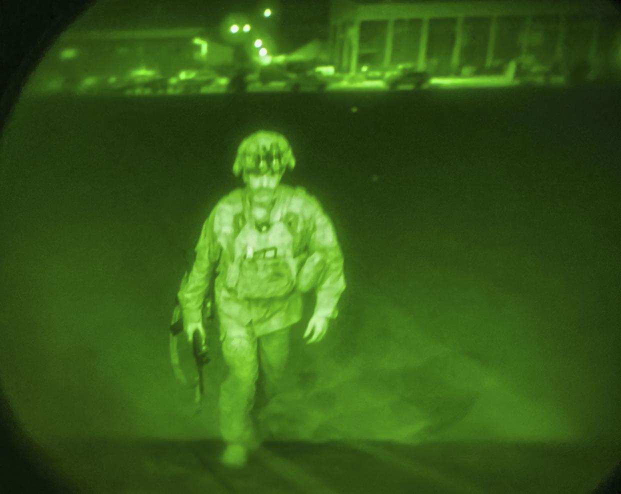 In this image made through a night vision scope and provided by U.S. Central Command, Maj. Gen. Chris Donahue, commander of the U.S. Army 82nd Airborne Division, XVIII Airborne Corps, boards a C-17 cargo plane at the Hamid Karzai International Airport in Kabul, Afghanistan, Monday, Aug. 30, as the final American service member to depart Afghanistan. 