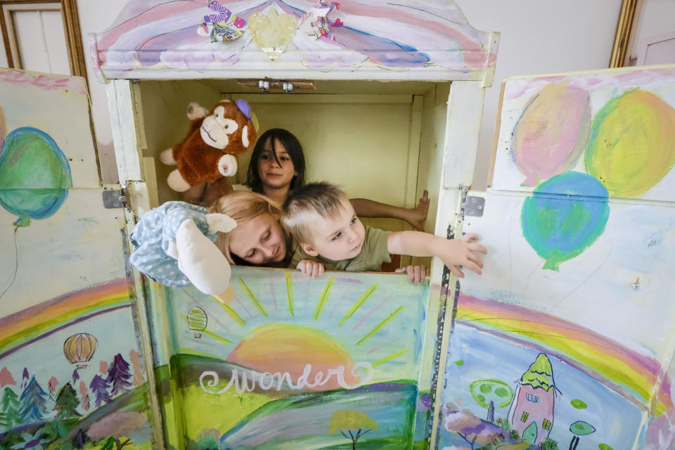Regan White, 10, left, Blythe Mumford, 10, and Wesley Mumford, 1, play in a puppet theater at Springfield Preparatory School in Springfield, La., Thursday, July 27, 2023. Nearly 9,000 private schools in Louisiana don’t need state approval to grant degrees. Non-approved schools make up a small percentage of the state total. But the students in Louisiana’s off-the-grid school system are a rapidly growing example of the national fallout from COVID-19 — families disengaging from traditional education. (AP Photo/Scott Threlkeld)