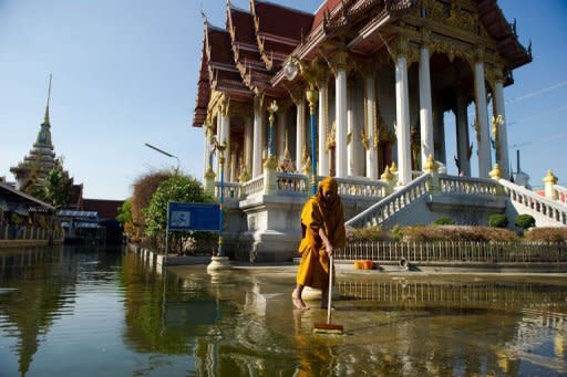 A Buddhist monk cleaning up an area at a temple inundated by flood waters in Don Muang district, in Bangkok, in 2011. Deadly floods, power blackouts and traffic gridlock -- many of Asia's biggest cities are buckling under the strain of rapid economic development, extreme weather and an exodus from the countryside