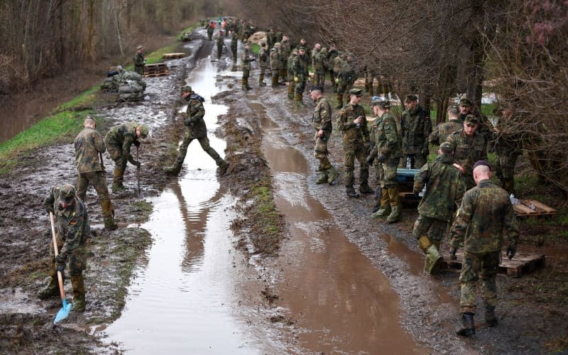 German Armed Forces (Bundeswehr) soldiers secure a dyke on the Helme with sandbags in the flood areas in Saxony-Anhalt Jan Woitas/dpa
