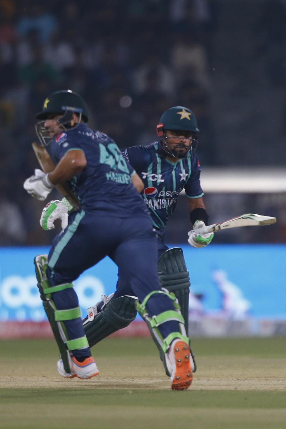 Pakistan's Babar Azam, right, and his batting partner Haider Ali run between the wickets during the sixth twenty20 cricket match between Pakistan and England, in Lahore, Pakistan, Friday, Sept. 30, 2022. (AP Photo/K.M. Chaudary)