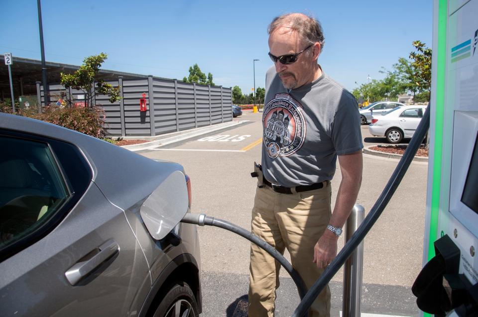 Claus Weigand attaches a charger to his Polestar 2 electric vehicle Wednesday at the Electrify America charging station at the Walmart on Trinity Parkway in Stockton.