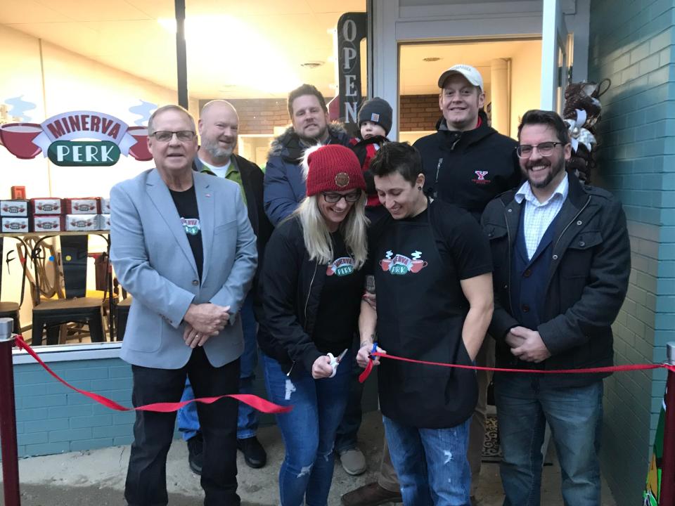 Celebrating the opening of Minerva Perk, a "Friends-themed coffee shop, are, front row from left, Mayor Tim Tarbet, Amanda Pace, Tiffany Sinay and Councilman Nathan Meadows; and, back row from left, Councilman Mason Boldizar, Village Administrator Phil Turske, Sam Turske and Councilman Matt Kishman.