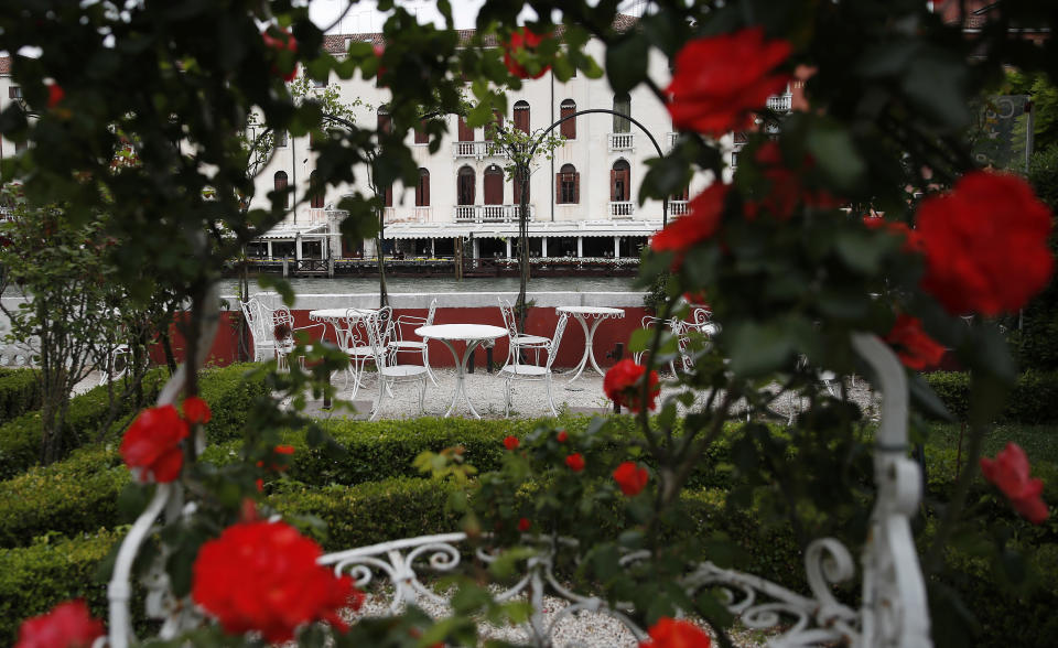 In this picture taken on Wednesday, May 13, 2020 rose bushes frame an empty garden overlooking a canal at the Ca' Nigra lagoon resort hotel along the canal grande in Venice, Italy. The hotel is currently closed to the public after lockdown measures to prevent the spread of COVID-19 brought national and International leisure travel to a halt. (AP Photo/Antonio Calanni)