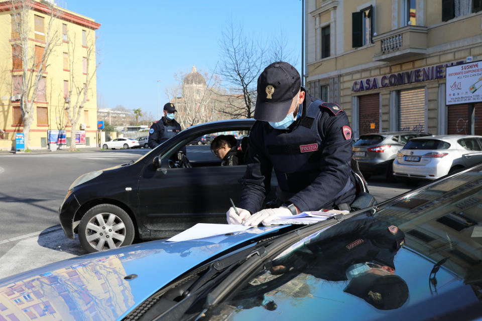 ROME, ITALY - MARCH 15: A Police patrol of the Ostia Commissariat checks if the occupants of a car are respecting the quarantine on March 15, 2020 in Rome, Italy. Ostias streets, one of Rome neighborhood were eerily quiet on the forth day of a nationwide quarantine. The Italian Government has taken the unprecedented measure of a nationwide lockdown by closing all businesses except essential services such as, pharmacies, grocery stores, hardware stores, tobacconists and banks, in an effort to fight the world's second-most deadly Coronavirus (COVID-19) outbreak outside of China.The movements in the streets are allowed only for work reasons and health reasons proven by a medical certificate. Citizens are encourage to stay home and have an obligation to respect the safety distance of one meter from each other in a row at supermarkets or in public spaces. According to the Ministry of the Interior, of the over half a million people controlled by the police in the past four days, over 20 thousand people have been reported for violating the quarantine. (Photo by Marco Di Lauro/Getty Images)