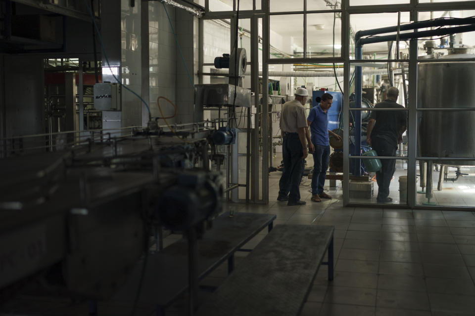 Palestinian employees work at the Pepsi bottling plant in Gaza City, Monday, June 21, 2021. Israel on Monday eased some restrictions on the Gaza Strip however the Pepsi factory announced today that it was closing and laying off workers because raw materials needed to stay in business are still not coming. (AP Photo/Felipe Dana)